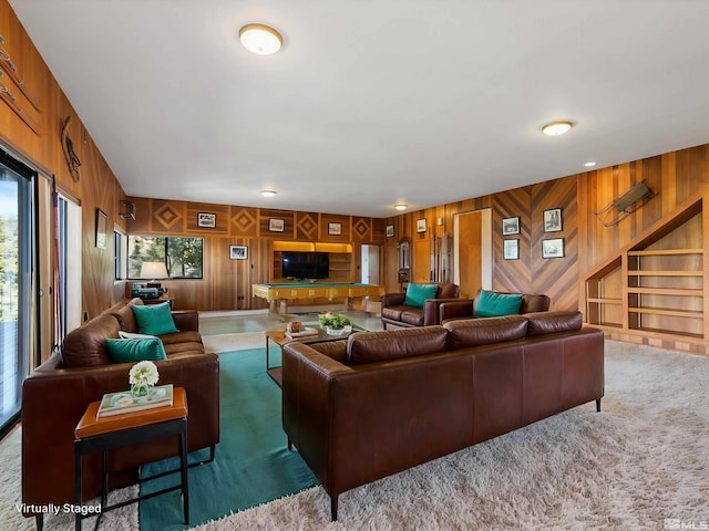 living room featuring dark carpet and wooden walls