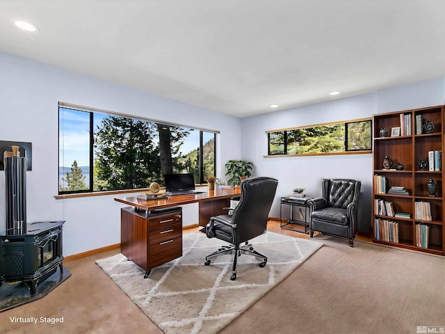 carpeted office featuring a wood stove