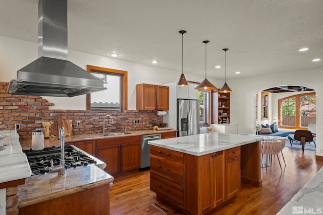 kitchen featuring appliances with stainless steel finishes, island exhaust hood, a wealth of natural light, and hanging light fixtures