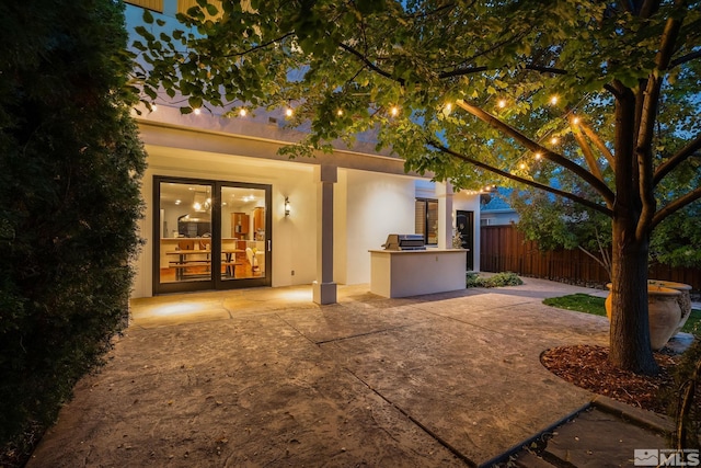 rear view of house with french doors, a patio, and area for grilling