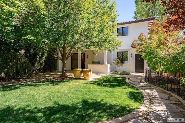 view of front facade featuring a front yard and a patio area