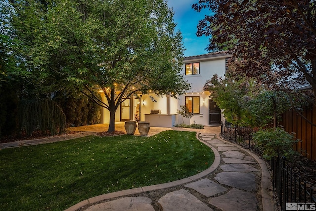 exterior space with an outdoor kitchen, a front yard, and a patio area