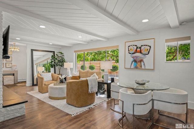 living room featuring an inviting chandelier, baseboard heating, beam ceiling, and dark hardwood / wood-style flooring