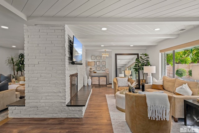 living room with a fireplace, beamed ceiling, wood ceiling, and dark hardwood / wood-style flooring