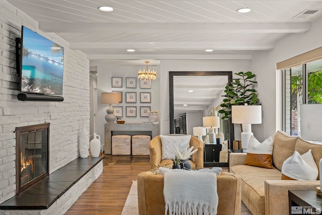 living room with a large fireplace, beamed ceiling, wood ceiling, and hardwood / wood-style flooring