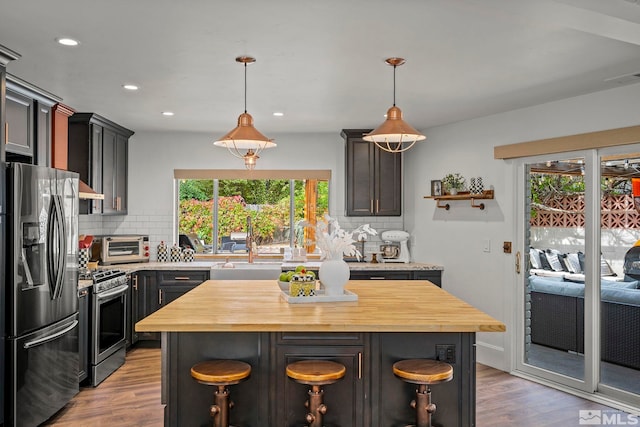 kitchen featuring stainless steel appliances, backsplash, a kitchen breakfast bar, and a kitchen island