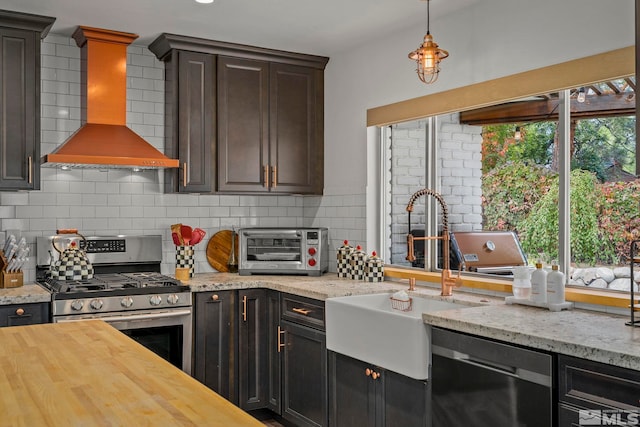 kitchen featuring wooden counters, tasteful backsplash, dark brown cabinets, stainless steel appliances, and custom exhaust hood