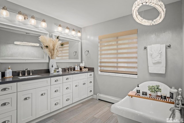 bathroom with vanity, a baseboard radiator, and a bathing tub