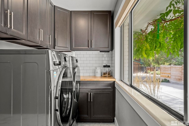 washroom featuring cabinets and washing machine and clothes dryer