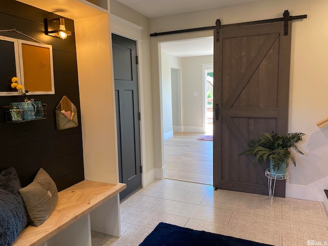 mudroom featuring light wood-type flooring and a barn door