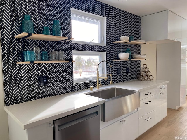 kitchen featuring dishwasher, light hardwood / wood-style flooring, sink, and a wealth of natural light