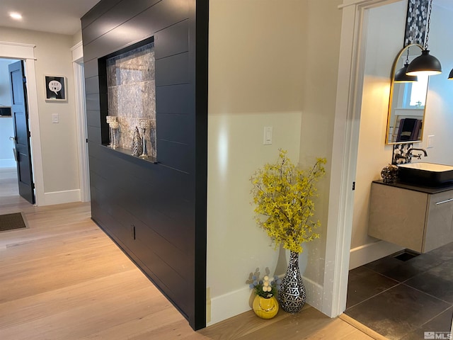 corridor featuring light hardwood / wood-style floors and sink