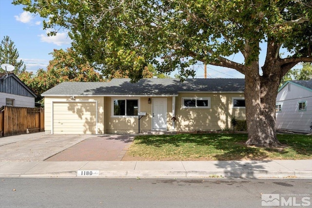 single story home featuring a garage and a front yard