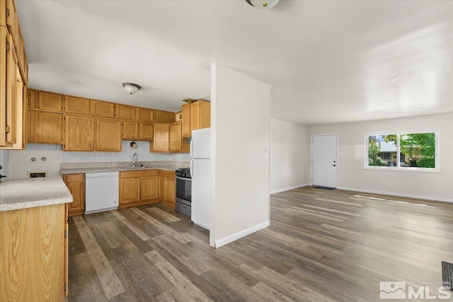 kitchen featuring white appliances, dark hardwood / wood-style flooring, and sink