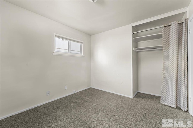 unfurnished bedroom with a closet and carpet flooring