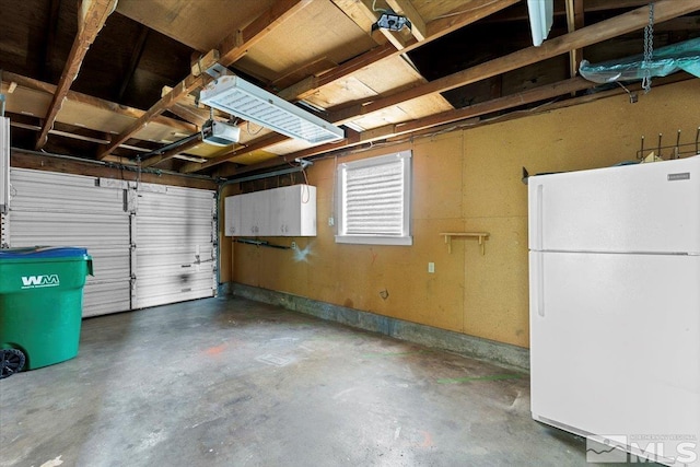 garage featuring white refrigerator and a garage door opener