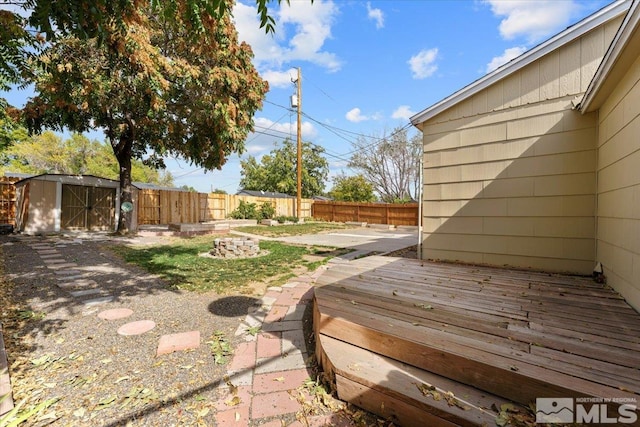 view of yard with a wooden deck and a storage shed