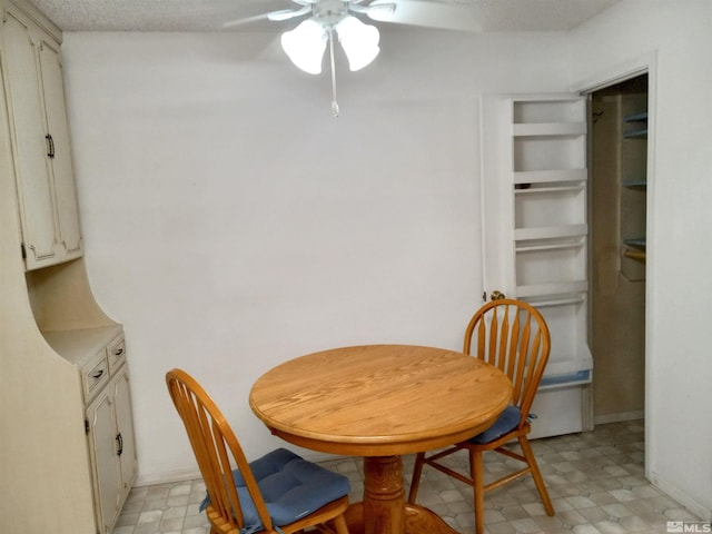 dining area with a textured ceiling and ceiling fan