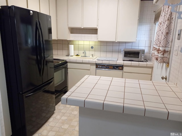 kitchen with black appliances, sink, tile counters, white cabinets, and decorative backsplash