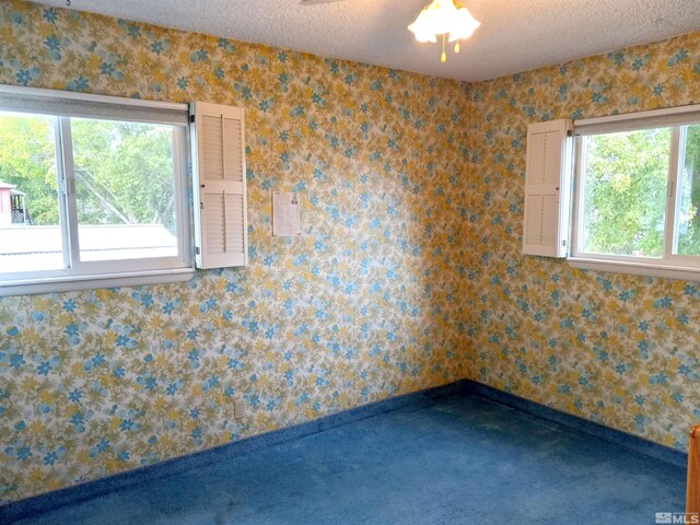 unfurnished room featuring ceiling fan and a textured ceiling