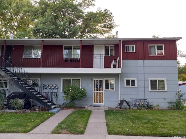 view of front facade featuring a balcony and a front lawn