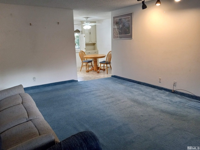 carpeted living room featuring a textured ceiling and ceiling fan