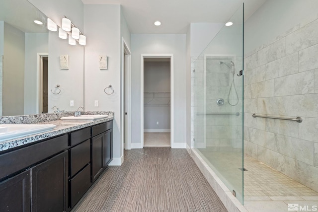 bathroom with vanity and a tile shower