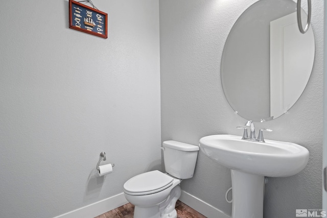 bathroom with wood-type flooring and toilet