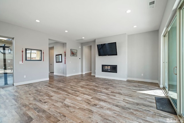 unfurnished living room with plenty of natural light and light hardwood / wood-style floors