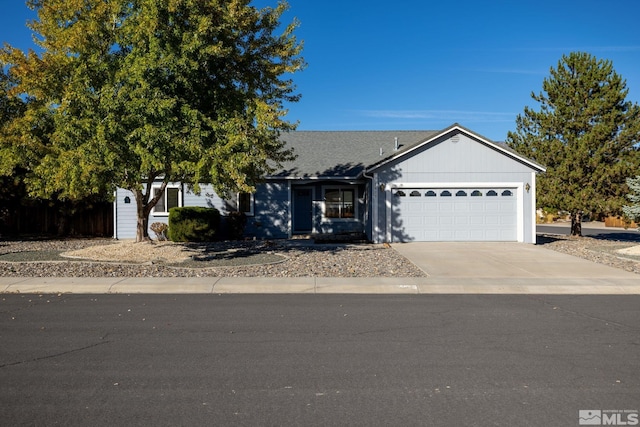 single story home featuring roof with shingles, a garage, and driveway