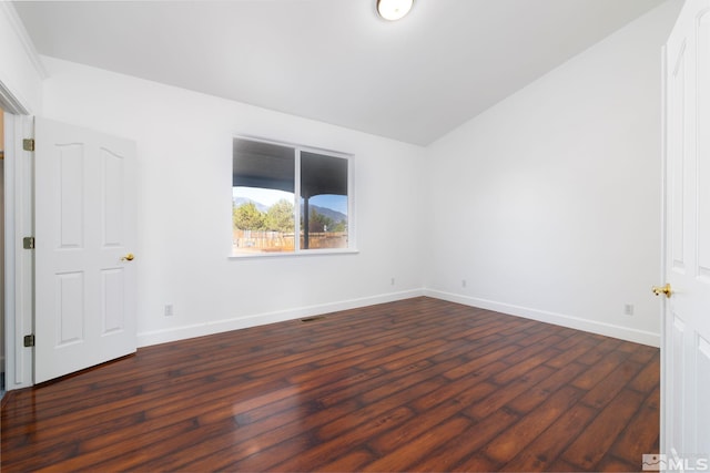 spare room with lofted ceiling and dark hardwood / wood-style flooring