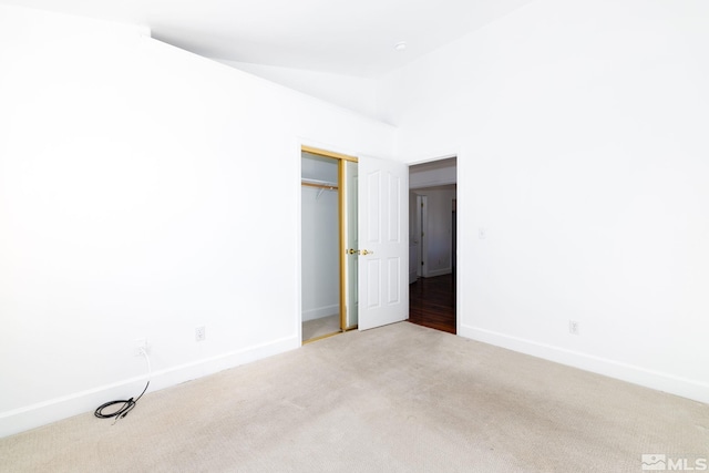 carpeted empty room featuring vaulted ceiling