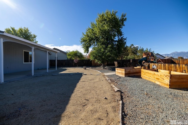 view of yard with a playground, a patio, and a mountain view