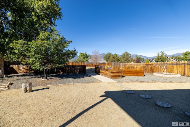 view of yard with a mountain view and fence