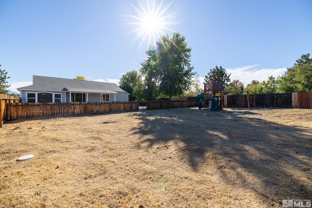 view of yard featuring a fenced backyard and a playground