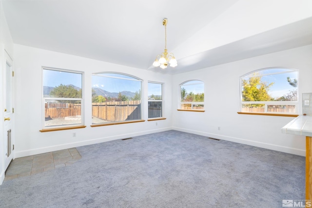 interior space featuring visible vents, baseboards, an inviting chandelier, carpet floors, and lofted ceiling
