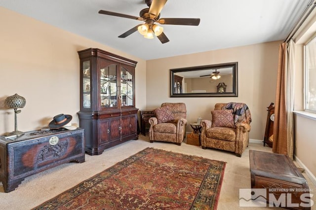 living area with ceiling fan and light carpet