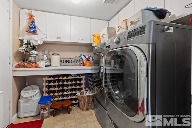 washroom featuring washer and dryer and cabinets