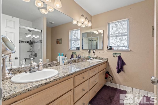 bathroom with vanity and a shower with shower door