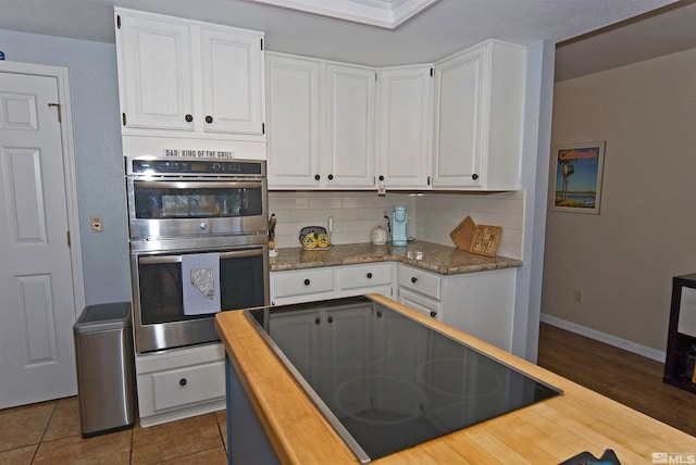 kitchen featuring stainless steel double oven, backsplash, white cabinets, and dark hardwood / wood-style flooring