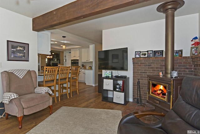 living room with a wood stove, beamed ceiling, and dark hardwood / wood-style floors