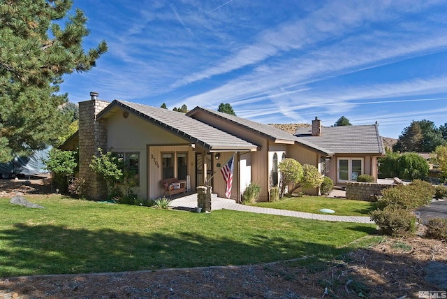 ranch-style home with a front lawn and a patio