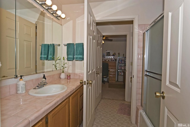 bathroom with bath / shower combo with glass door and vanity