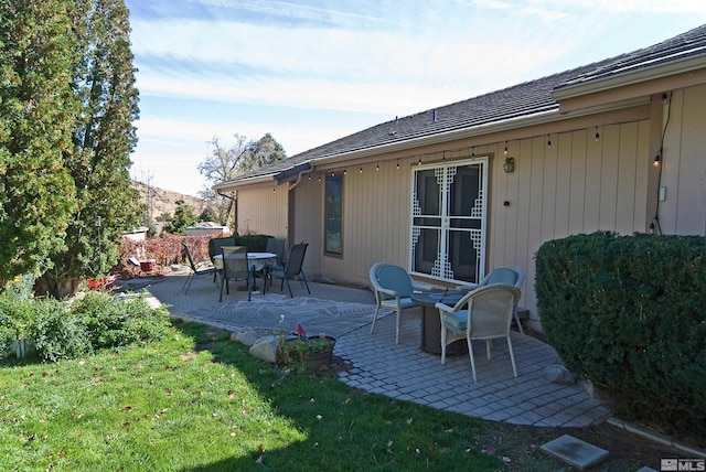 rear view of property with a lawn and a patio