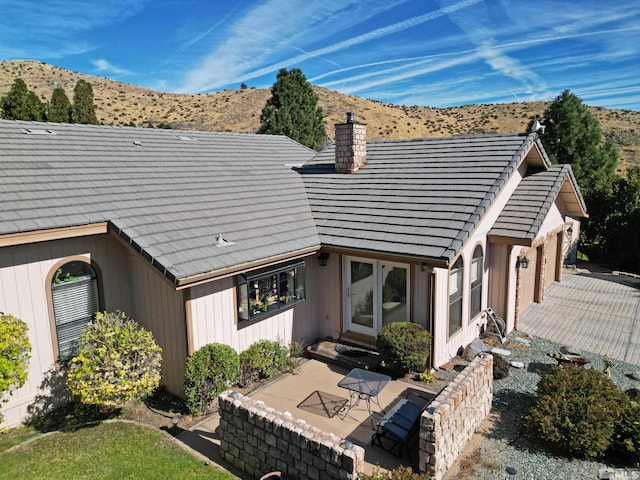 rear view of house featuring a mountain view and a patio