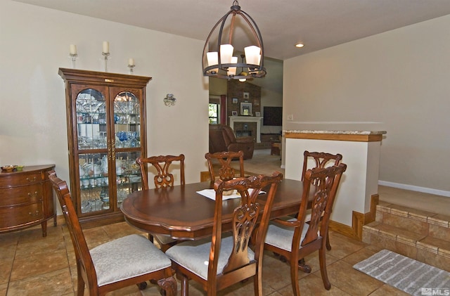 dining room with a large fireplace and a notable chandelier