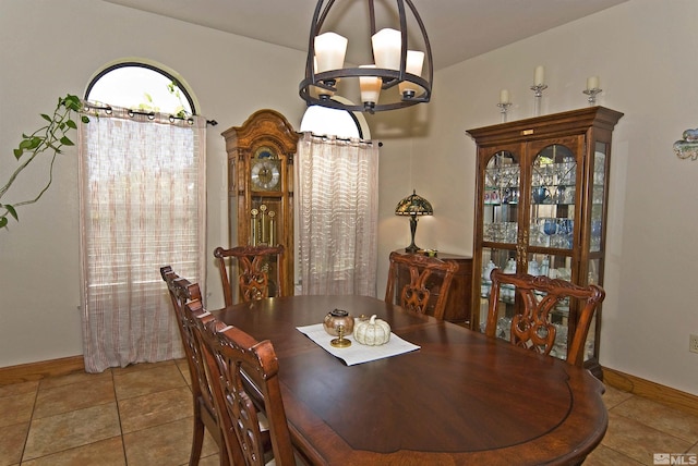 dining space with light tile patterned floors, lofted ceiling, and a chandelier