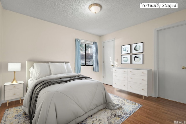 bedroom with dark wood-type flooring and a textured ceiling