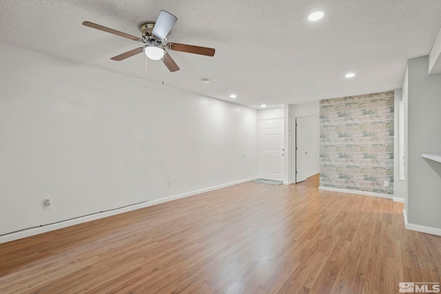 spare room with ceiling fan, a textured ceiling, and light hardwood / wood-style flooring