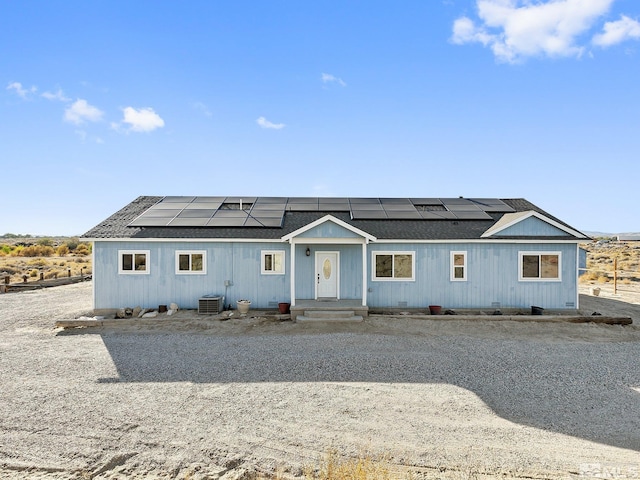 view of front of home with solar panels and central AC